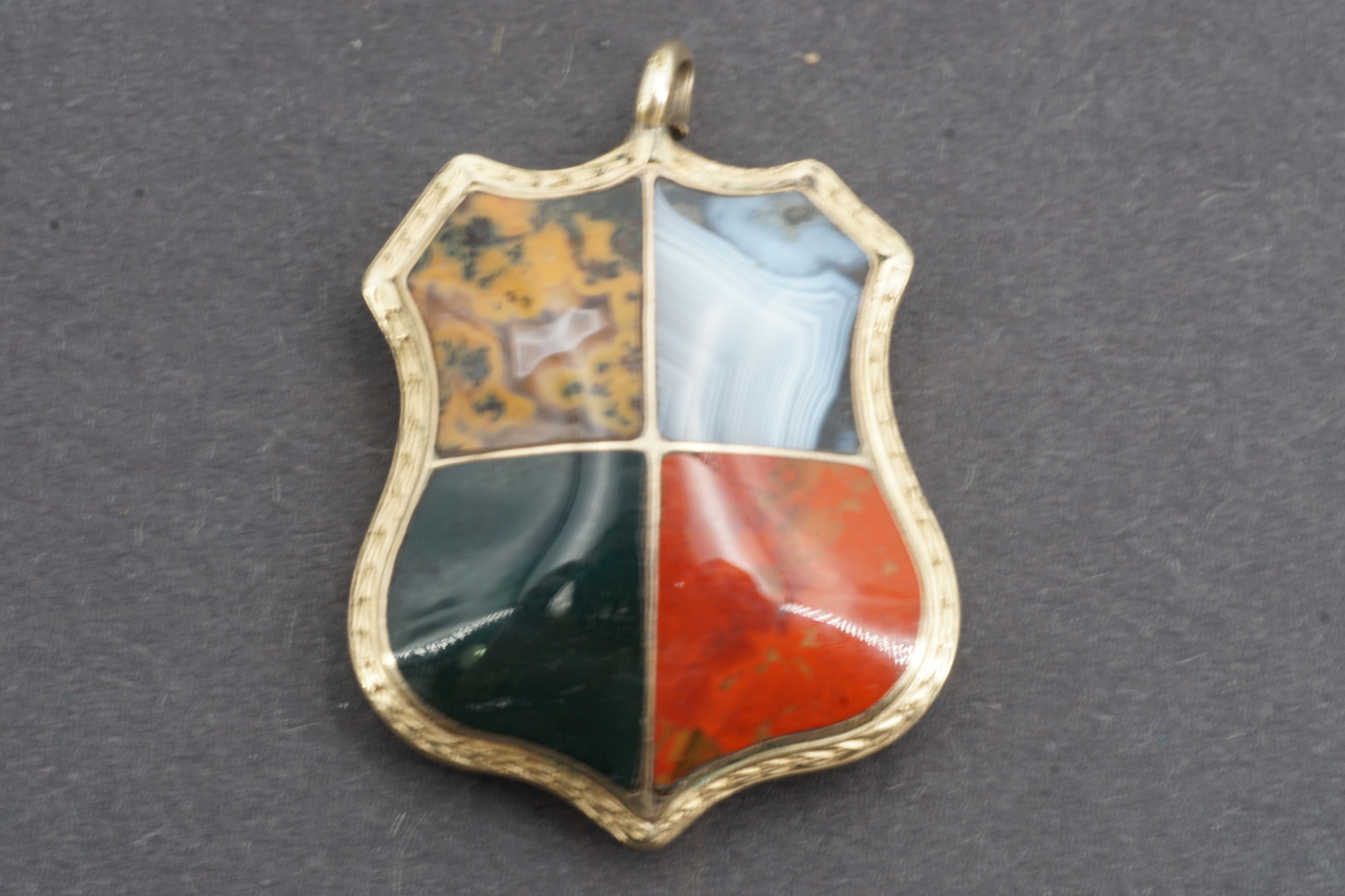 A Victorian yellow-metal 'pebble' and hairwork fob in the form of a shield, the domed and polished