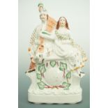 A Victorian Staffordshire-type 'clock' mantle ornament, modelled as a lady and gentleman in Scottish