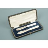A George V cased set of two silver and mother of pearl handled butter knives, George Bishop and