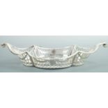 An Edwardian silver Neoclassical basket, of quatrefoil section and boat form tapering to volute
