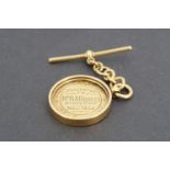 A 1920s 18ct gold presentation fob medallion with T bar suspender, circular section, engraved "