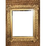 An ornate gilt bevel edged mirror, 32 x 37 cm