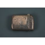 An Edwardian silver Vesta case, of cushion form, foliate-scroll engraved, one face centred by a