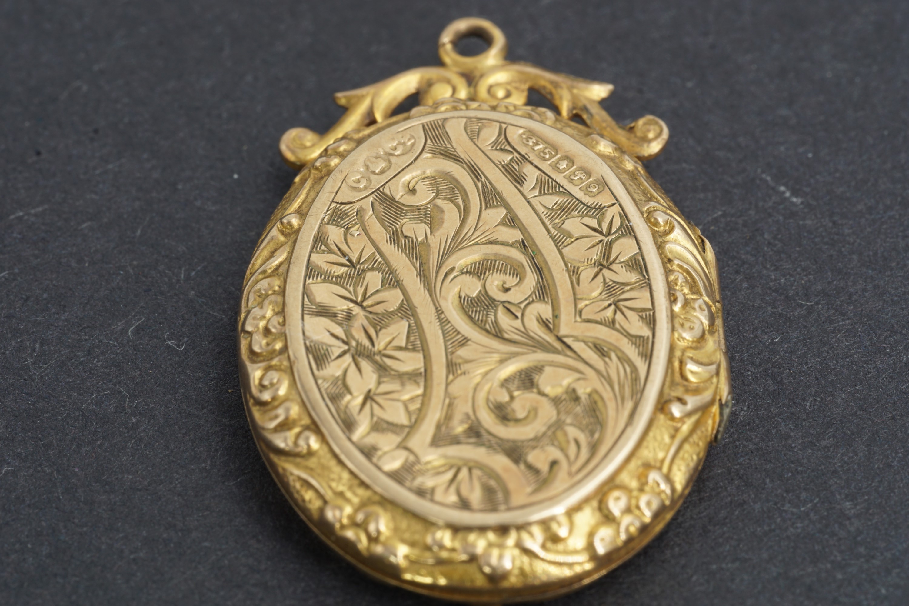 An early 20th Century 9 ct gold pendant locket, foliate-scroll-engraved and having an adorsed scroll - Image 2 of 2