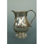 An Elizabeth II silver cream jug, of baluster form, with double scroll handle, sparrow-beak spout,