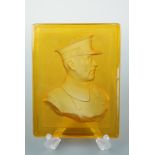 A Great War pressed amber glass plaque bearing an intaglio portrait of King Albert I of Belgium,