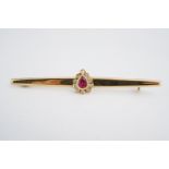 A 14ct gold, diamond and ruby bar brooch, with central pear cut ruby of approximately .30ct, rub set