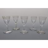 Five George III facet-stemmed wine glasses, each having an engraved conical funnel bowl, 11.5 cm, (