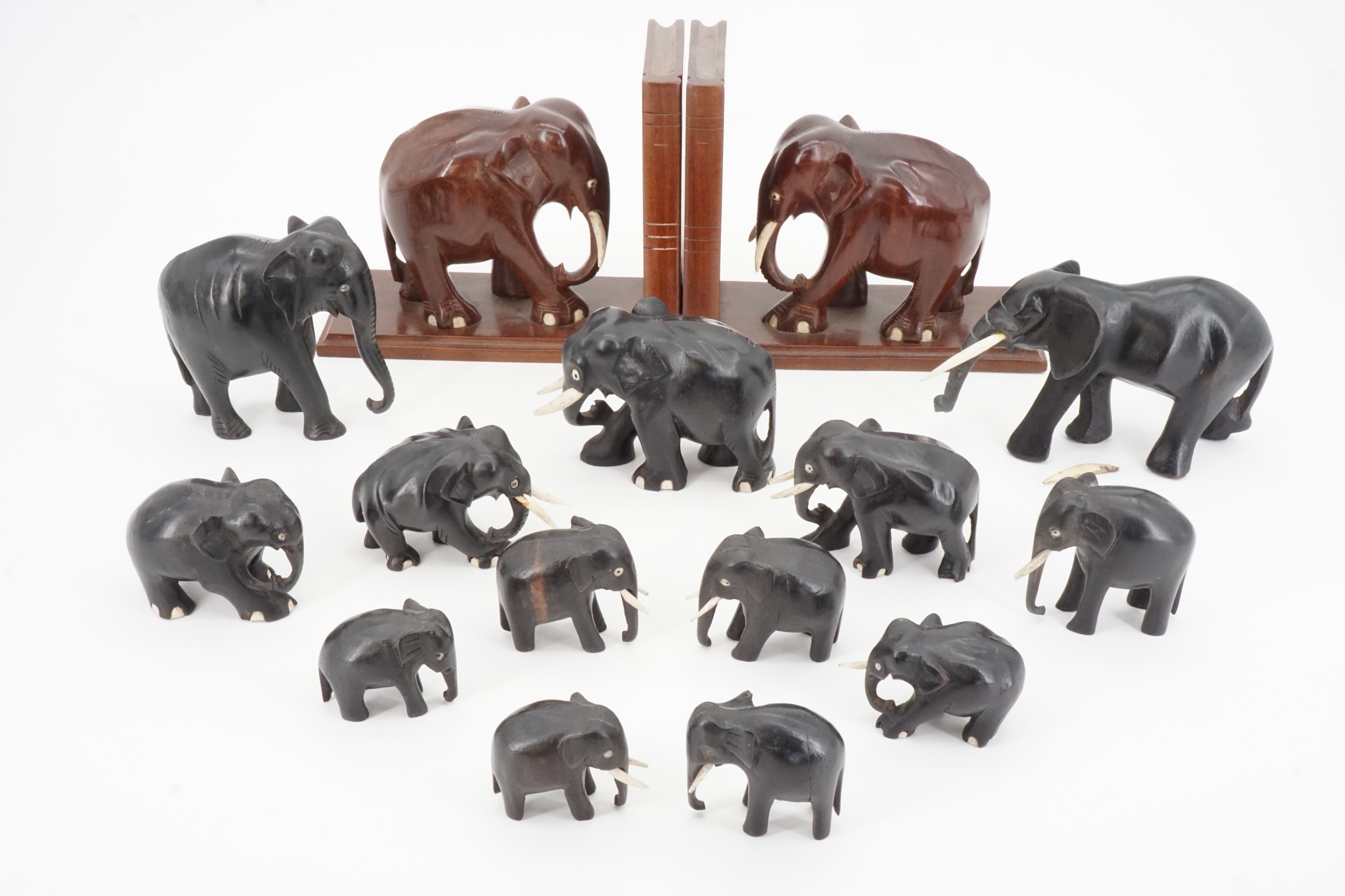 Carved wooden elephant bookends together with other elephant ornaments