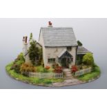 A hand-built scale model of a 19th Century Lakeland two-storey lime-washed cottage, situated on a