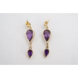 A pair of amethyst and 9 ct gold ear pendants each comprising two bezel set graded pendeloque cut