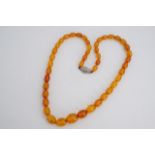 A vintage amber bead necklace, 49 cm, largest bead 12 x 16 mm, 20.2 g