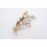 A fine late 19th / early 20th Century pearl-set yellow metal brooch in the form of a ribbon-bow-tied