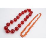 A vintage branch coral necklace together with a necklace of large cherry-coloured glass beads,