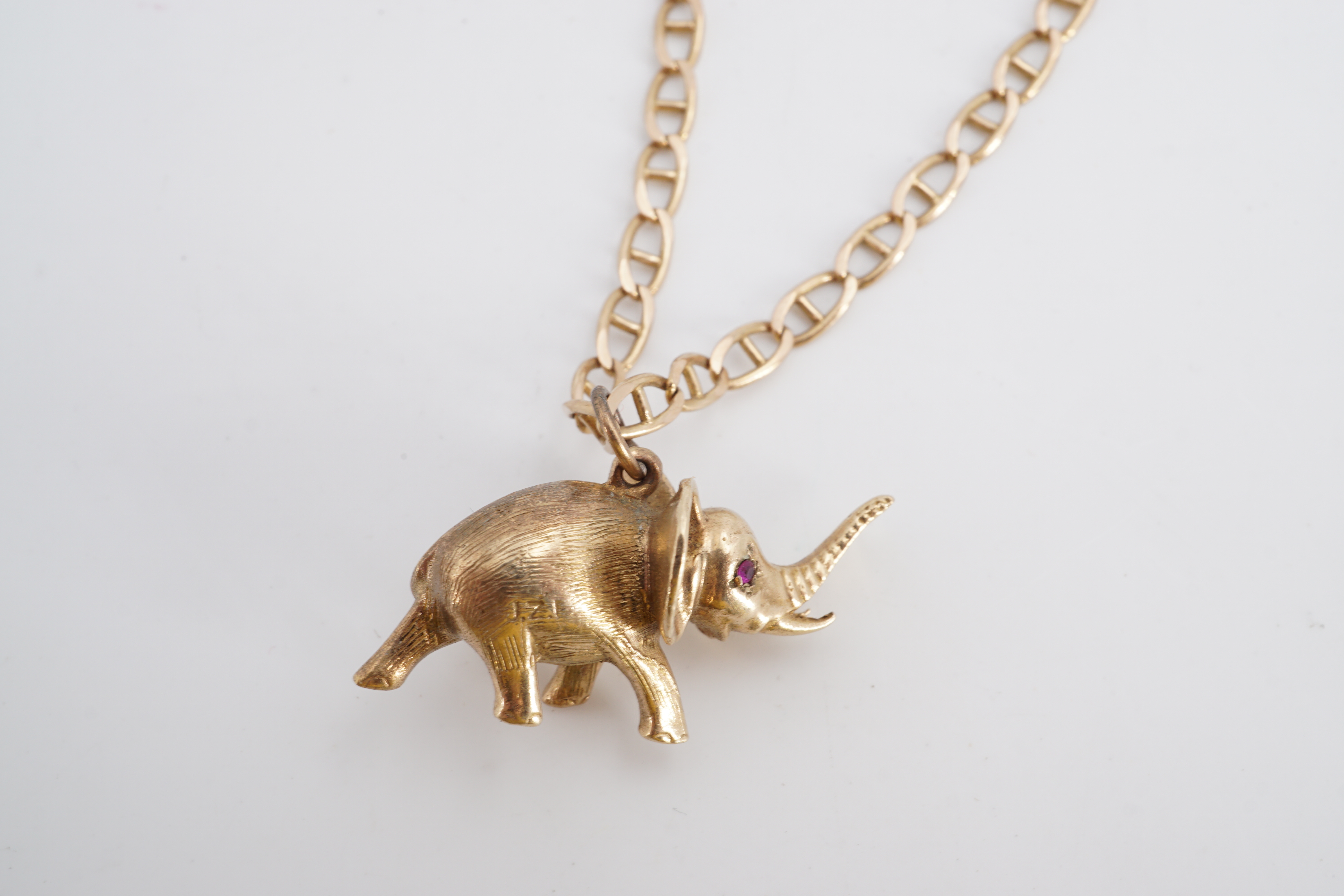 A yellow metal pendant modelled as an elephant, having ruby eyes, on a 9 ct gold marine link neck - Image 2 of 2