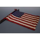 An antique white-metal mounted evening cane and an American flag