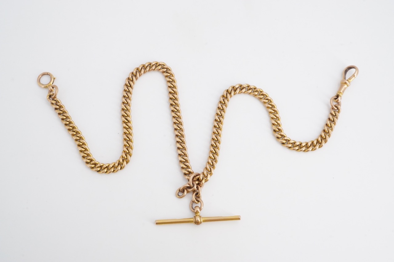 An early 20th Century 9 ct gold double watch chain of graded curb links with T-bar, swivel and