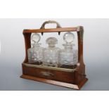 A late 19th / early 20th Century oak tantalus (decanters (a/f))