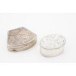A small silver oval-section pill box together with a fan-shaped white metal example, 20th Century