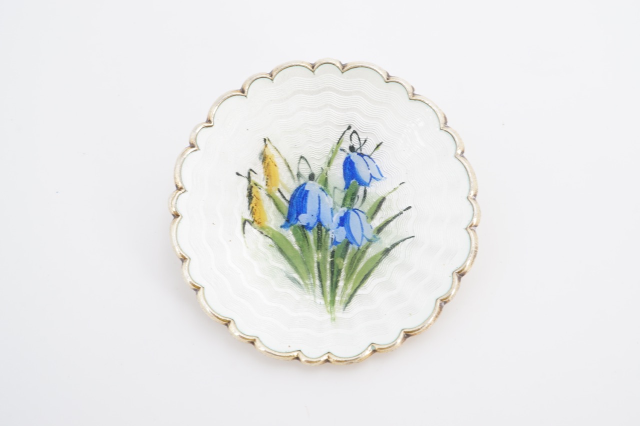 A Norwegian enamelled white metal brooch, of dished and scalloped form, basse taille enamelled