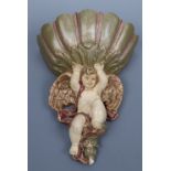 A Baroque style painted ceramic wall pocket in the form of a cherub and shell, late 20th Century, 28