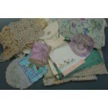 A quantity of vintage hand-embroidered table linens and crocheted doilies, many table cloths