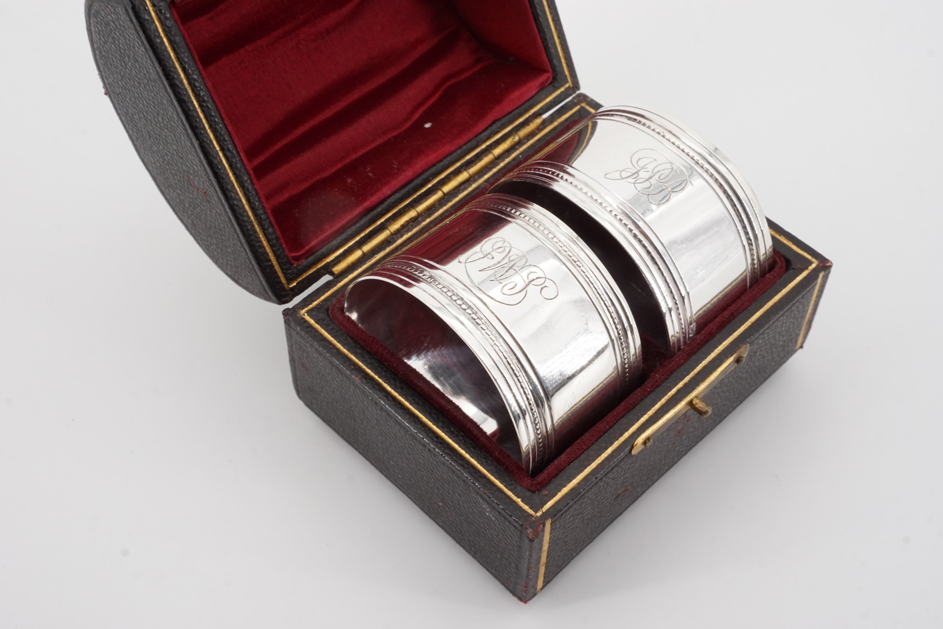 A cased pair of Victorian silver napkin rings, each of cylindrical form bearing reeded and beaded - Image 3 of 3