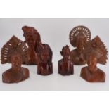 Six Balinese carved wooden busts, tallest 24 cm