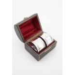 A cased pair of Victorian silver napkin rings, each of cylindrical form bearing reeded and beaded