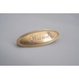 A vintage yellow metal oval plaque brooch bearing the engraved name Diana in cursive script, stamped