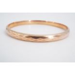 A 1930s 9 ct gold circular bangle, decorated with diamond facets overall, 7.5 cm, 8.8 g