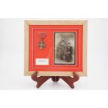 A framed French Croix de Guerre medal and portrait postcard