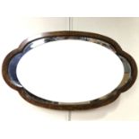 A 1930s cloud form oak framed wall mirror, 73 x 43 cm