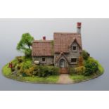 A hand-built built scale model of a two-storey Lakeland stone cottage, with enclosed garden