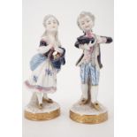 A pair of continental boy and girl figurines;