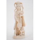 An early 20th Century Japanese ivory okimono depicting a woman in fine dress carrying a fan and