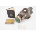 A Second World War Civilian Duty gas mask, anti-gas ointment and first aid manual