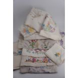 A selection of fine hand-embroidered table cloths each decorated with a delicate floral pattern or