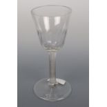 A mid-18th Century wine glass, its pointed round funnel bowl decorated with basal flutes, the stem