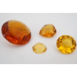 Four faceted glass gemstones, three circular cut and one heart-shaped, largest approximately 2.5 cm