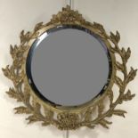 A circular wall mirror with laurel garland surround, 65 cm x 68 cm