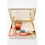 A 1960s tinplate first aid case and contents the lid bearing a Ministry of Labour Form SHW1 Offices,