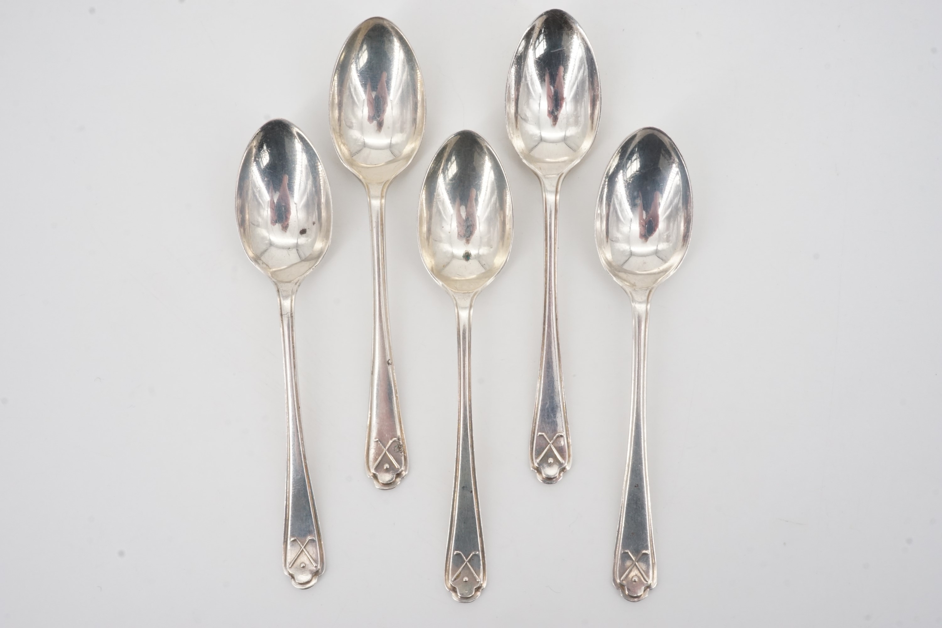 Five 1930s silver coffee spoons, their terminals faced with a crossed golf club and ball device,