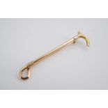 A late Victorian / Edwardian yellow metal brooch in the form of a riding whip, stamped PT & 15 ct,
