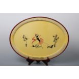 A vintage kitsch tinplate tea tray hand-enamelled in depiction of a fashionable young lady walking a