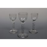 Three George III faceted-stem wine glasses, each having border-engraved ogee bowl, 13 cm, (rim