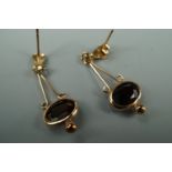 A pair of garnet and yellow metal ear pendants, 2.5 cm