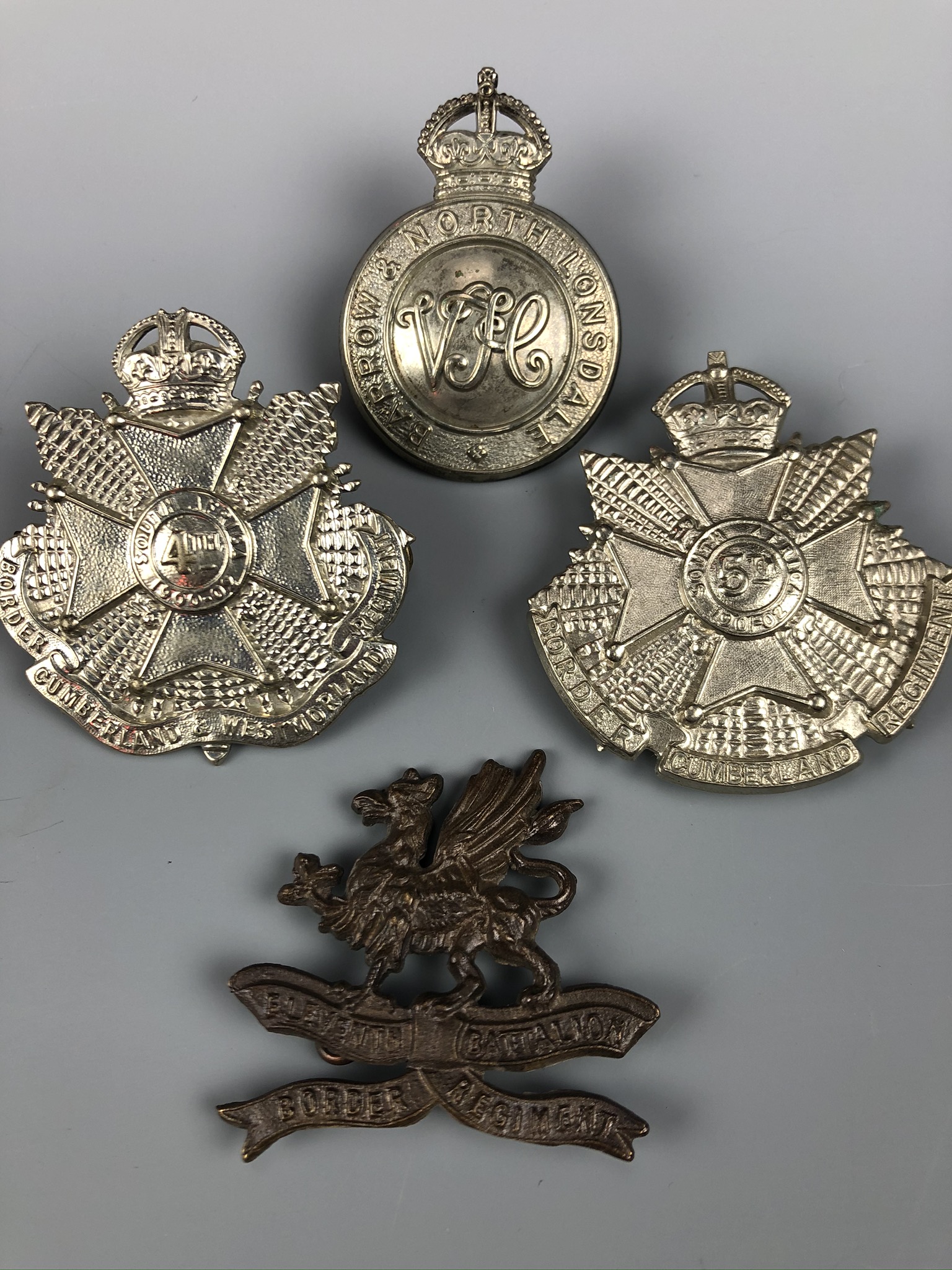 An 11th (Lonsdale) Battalion Officer's Service Dress cap badge together with 4th and 5th Battalion