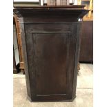 An early 19th Century oak corner cabinet, 113 cm