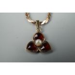 A trefoil garnet and seed pearl pendant on a 9 ct gold flat S-link neck chain, 43 cm, 5.4 g